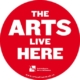 Red circle with white text that reads "the arts live here" the Saskatchewan Arts Alliance logo at the bottom of circle.