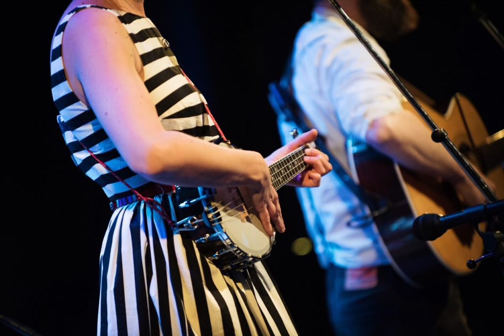 A woman playing a banjo and a man a guitar