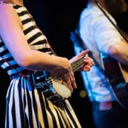 A woman playing a banjo and a man a guitar