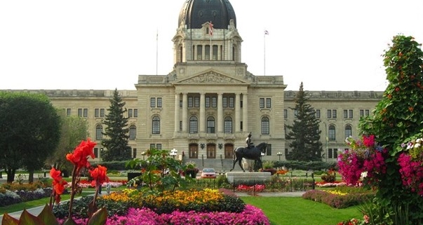 SK Legislative building behind a yard of flowerbeds and a grass walkway