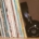 Spines of vinyl records in cardboard cases leaning to the left with black headphones against the records