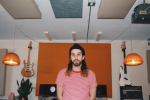 Mario LePage from the band ‘Ponteix standing between two electric guitars..’ Photo Credit: Stephenie Kuse