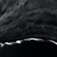 Black and white image of waves hitting the shores - viewpoint from the top.