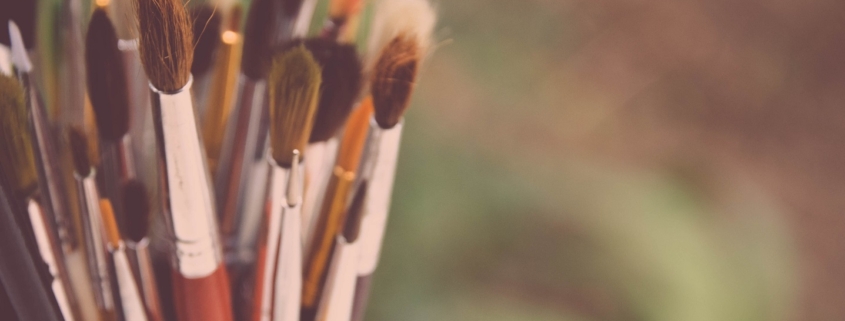 A cup filled with dry paint brushes