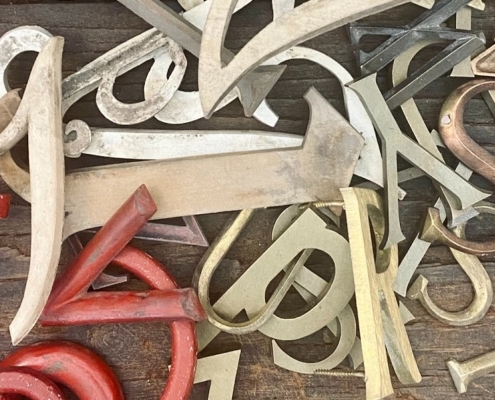 jumbled up letters in a pile from red to brass
