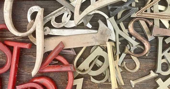 jumbled up letters in a pile from red to brass