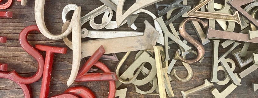 jumbled up letters in a pile from red to brass