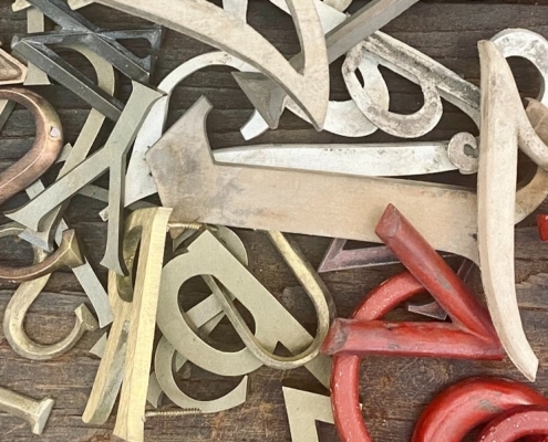 jumbled up letters in a pile from red to brass