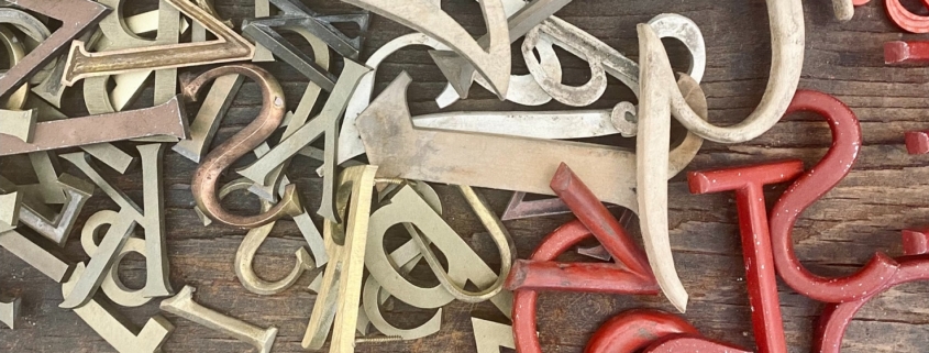 jumbled up letters in a pile from red to brass