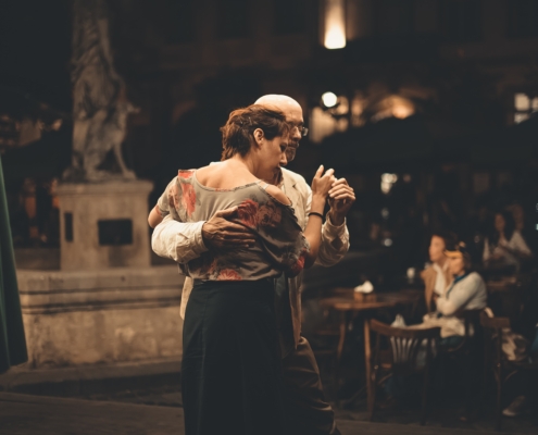 Two older adults dancing in each others arms.