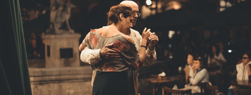 Two older adults dancing in each others arms.