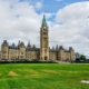 Canadian Parliament against a cloudy blue sky.