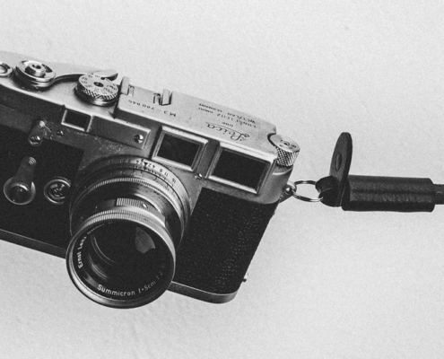 Black and white image of a analogue camera on a grey background