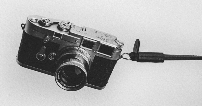 Black and white image of a analogue camera on a grey background