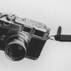 Black and white image of a analogue camera on a grey background