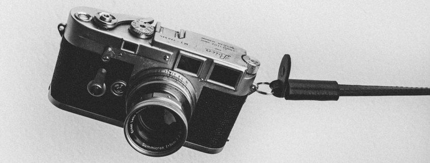 Black and white image of a analogue camera on a grey background