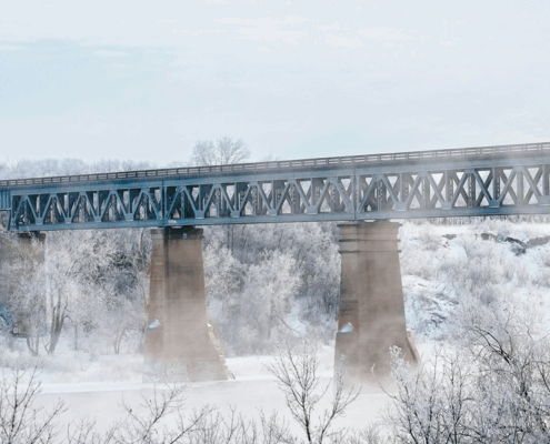 Saskatoon bridge on a cold and crisp day. Light blue sky and mist coming up from the snowy ground