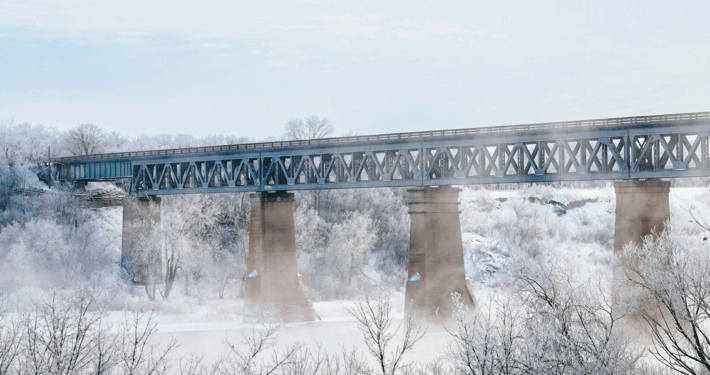 Saskatoon bridge on a cold and crisp day. Light blue sky and mist coming up from the snowy ground