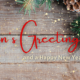 Season's Greetings written in red text with green pine cones in the background