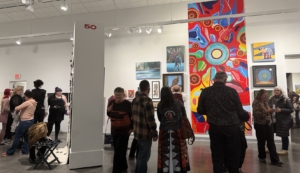 Visitors gathered inside the Mann Art Gallery during the Winter Festival Show and Sale, with artworks filling the walls.