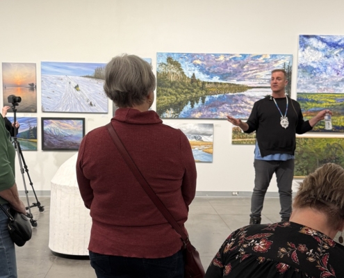 Jason Baerg speaking to a group of visitors during a curatorial talk inside the Mann Art Gallery.