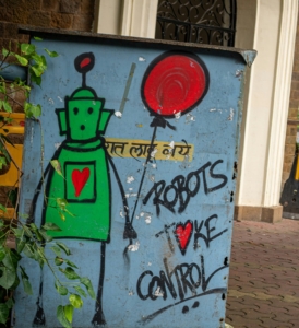 Graffiti depicting a green robot holding a red balloon with text that reads Robots take control