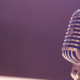 old fashioned metal ball microphone against a flat blue background