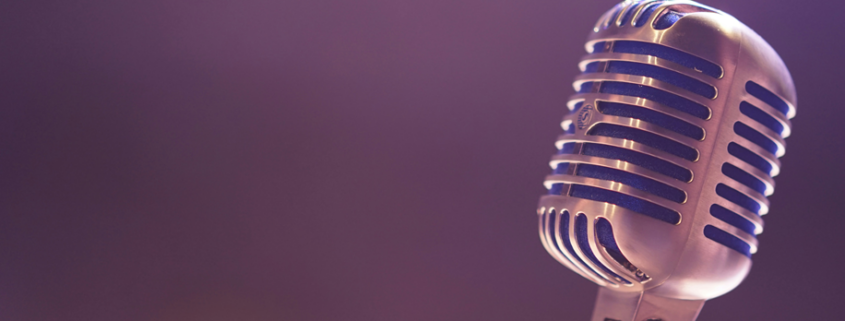 old fashioned metal ball microphone against a flat blue background